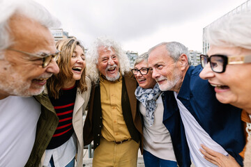 Happy senior group of people having fun together outdoor. Elderly generation friends laughing while...