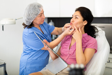Experienced cosmetology doctor working in the clinic does a mechanical facial cleaning a young...