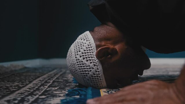 Muslim man bowing on a prayer rug and praying