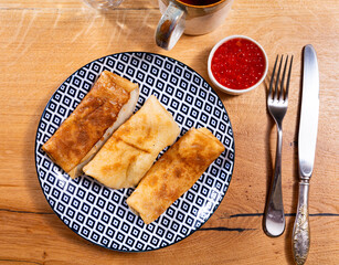 Tasty russian pancakes with red caviar at plate