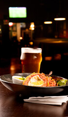 scotch egg with green salad and yellow mustard on plate m blurred background in pub half pint of craft beer