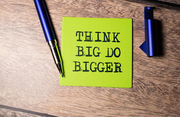 Think Big, Do Bigger Motivation quote written on a note paper.
