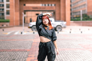A young Korean woman in casual wear with arms raised in a cityscape