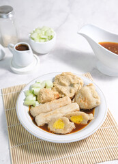 Pempek served cuko or vinegar sauce on white bowl