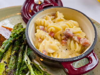 Carbonara pasta in a pot with asparagus