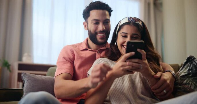 Happy, couple and relax on couch with smartphone for streaming videos, social media memes and entertainment. Man, woman and together in home with cellphone for research for new apartments in Mumbai.