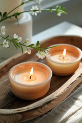Aromatic candles arranged on a wooden tray