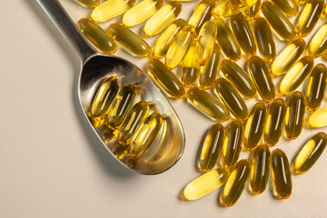 spoon with omega 3 fish oil pills with a golden yellow color, an indispensable nutrient
