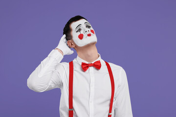 Mime artist making sad face on purple background