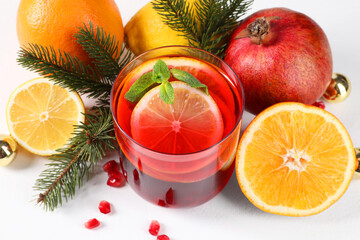 Christmas Sangria drink in glass, fir branches and fruits on white background, closeup