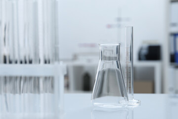 Laboratory analysis. Flask and test tubes on white table indoors