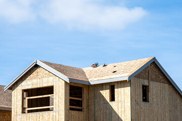 New home construction in a residential cottage community, house shells waiting for roofing and siding
