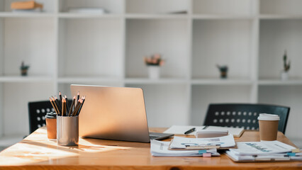 Minimalist office desk setup featuring a sleek laptop, a cup of coffee, and neatly arranged work...