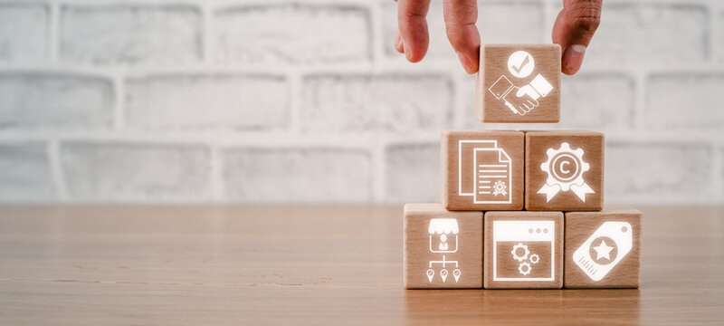 Intangible assets concept, Hand holding wooden block on desk with intangible assets icon on virtual screen.