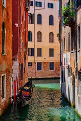 Narrow canal with gondola in Venice, Italy