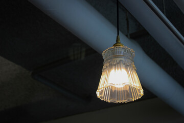 hanging light and concrete ceiling with pipe exposed