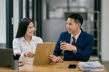 Two people in a business meeting, one of them holding a clipboard