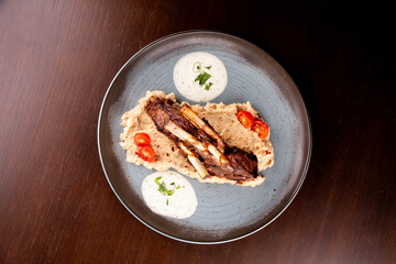 grilled rack of lamb with potatoes on wooden table in top view