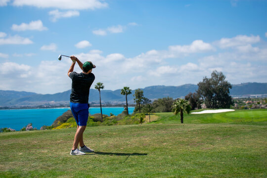 Man playing golf with ocean view