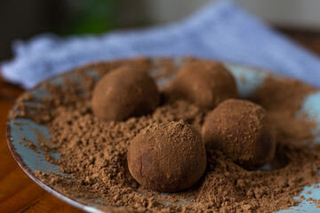 Trufas de chocolate jogadas em cima do cacau em pó