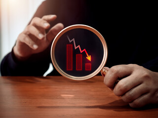 Red down arrow, decrease business graph down step, finance diagram in magnifying glass lens in businessman hand. Financial crisis, bankruptcy, loss investment economic recession sales risk concepts.