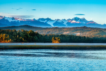 The snow covered Southern alps views from the West Coast’s Okarito Lagoon at sunrise
