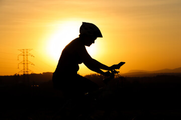 silhouette of person riding a bicycle in the late afternoon