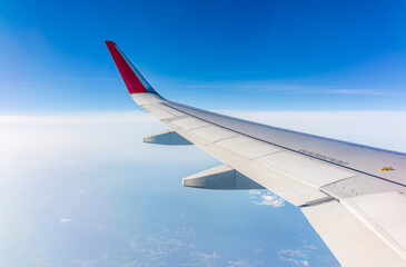 View from the airplane window at a beautiful cloudy sky and the airplane wing