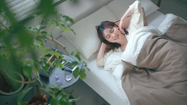 ベッドで横になる20代女性
