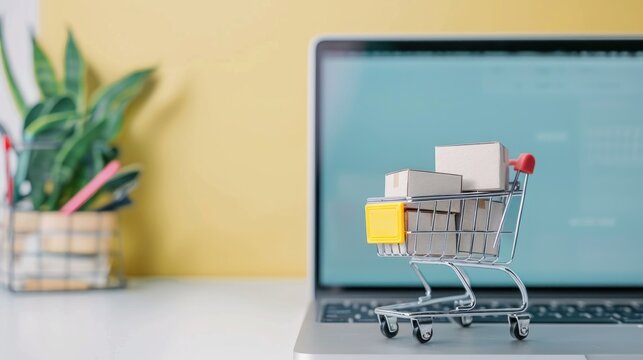 A laptop screen shows a shopping cart full of boxes.