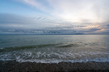 An incoming wave on the Black Sea coast against the sunset sky, Sochi, Krasnodar Territory, Russia