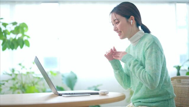リビングでオンラインミーティングをする20代女性