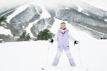 雪山でスキーをする小学生の女の子