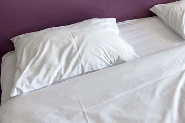 Fresh bed made in white linens in a hotel.