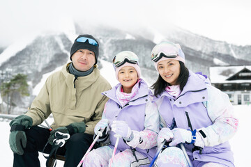 雪山でスキーを楽しむ家族,父母娘