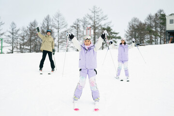 雪山でスキーを楽しむ家族,父母娘