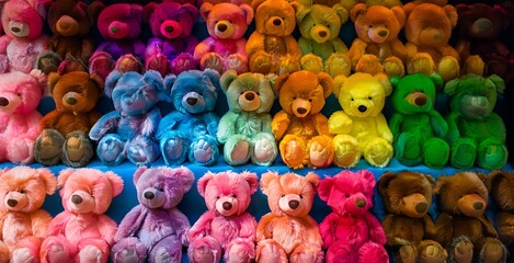 A vibrant array of colorful teddy bears, displayed in a spectrum of hues, from vibrant blues and greens to warm yellows and oranges, creating a delightful and visually captivating scene