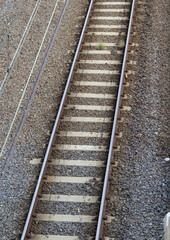 Close up view of railway tracks with parallel steel rails, wooden sleepers and a gravel bed