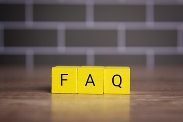 Wooden cubes with alphabet FAQ. Frequently asked questions concept.