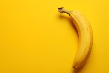 Conceptual image of a banana on a bright yellow background, emphasizing minimalism and the concept...