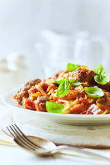 Spaghetti Pasta with Meatballs and fresh Basil o bright background. Close up.