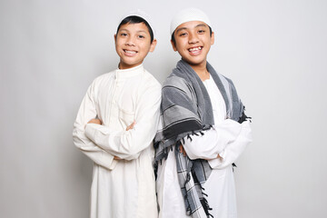 Two Muslim boys in white robe smiling happily isolated on white background