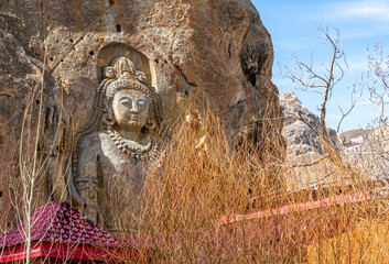 Stone carving of Buddha in a mountainside at the Mulbekh Buddhist Monastery in northern India