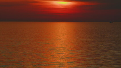 Beautiful Sunset Above Sea. Sun Sets Turning Red Tones And Reflects In Ocean.