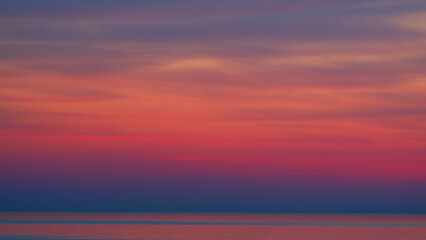 Fiery Purple Or Pink And Violet Colors Sunsets Over Ocean. Bright Sunset With Sun Over Calm Sea...