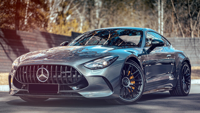 Novosibirsk, Russia - April    23, 2024 : silver  Mercedes-Benz  AMG GT 63 S 4MATIC ,  front  view,   against  city  in  summer  time