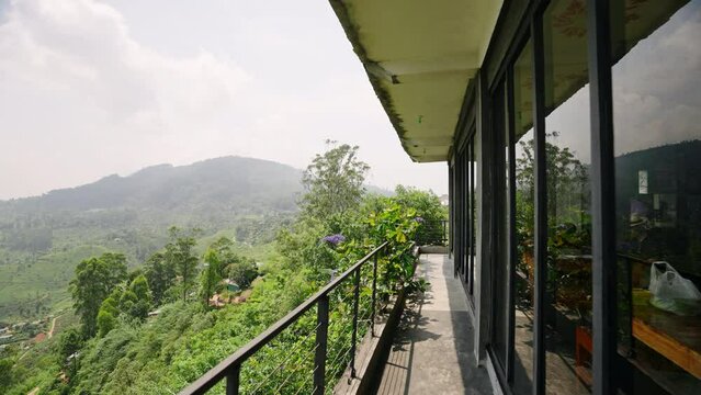 Panoramic view from balcony over rich green tea fields in Haputale, Sri Lanka. Clear blue sky above layered hills draped in plantation crops. Tourist spot, tranquil rural landscape for travel, nature.