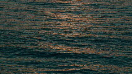 Vibrant Sea Surf With Sunset Light Reflection. Sun Reflects And Sparkles On Waves With Bokeh Lights.