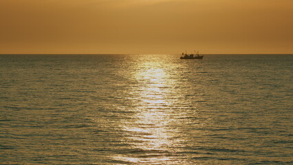 Fishing Boat On The Horizon At Sea. Abstract Small Waves On Calm Water Surface In Motion.