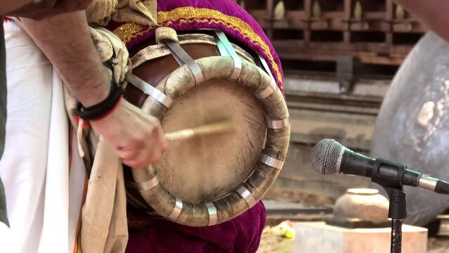 Artist playing Thavil, a South Indian percussion musical instrument	